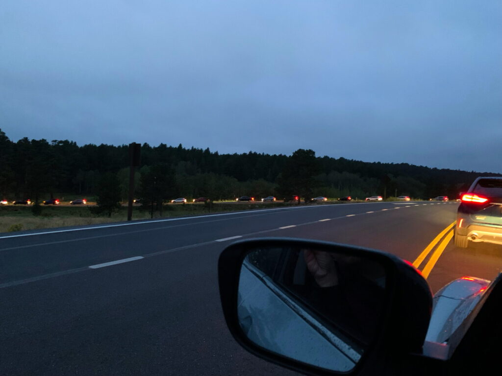 A long line of cars waiting to enter Bear Lake Road before sunrise