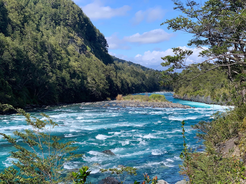 Bright blue water in a river at the bottom of Petrohue Falls near Puerto Varas