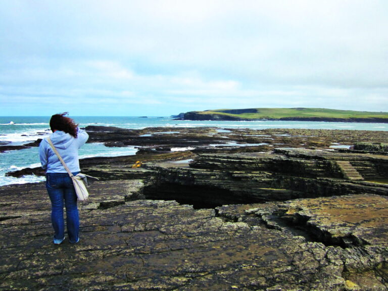 Person looking out at the cliffs in western Clare