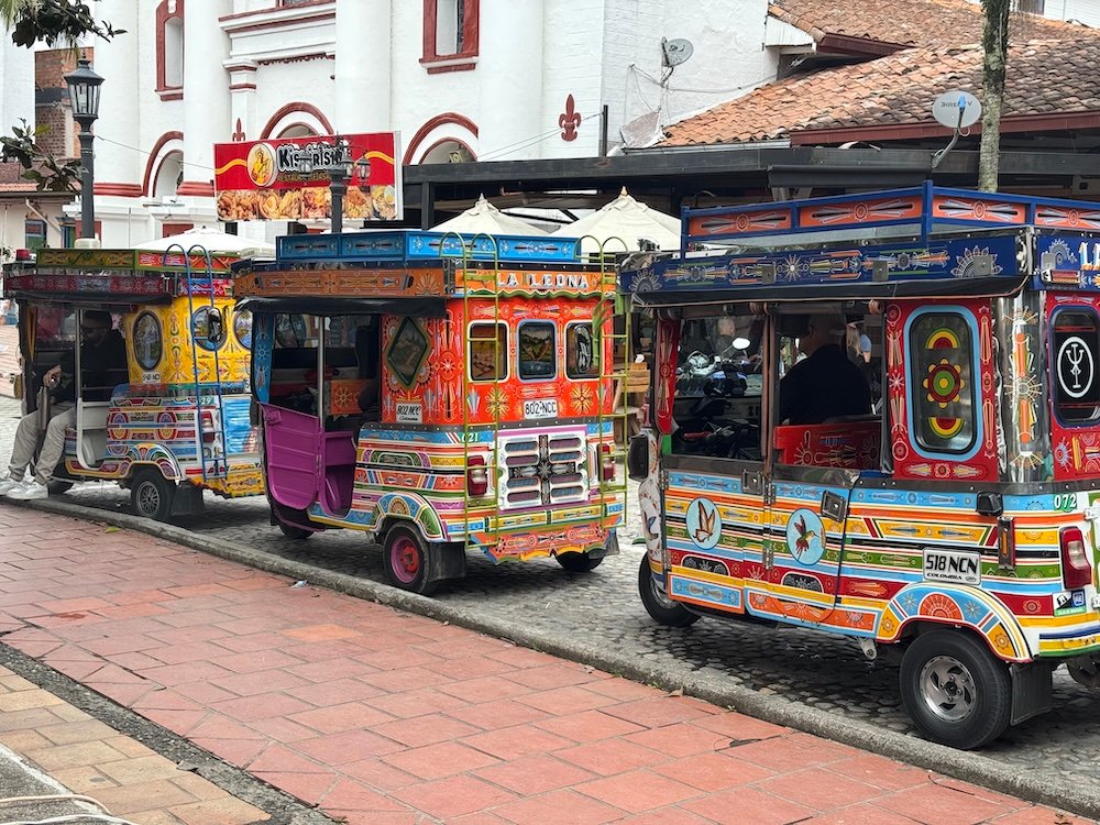 Colorful tuktuks lined up in along the main square in Guatapé