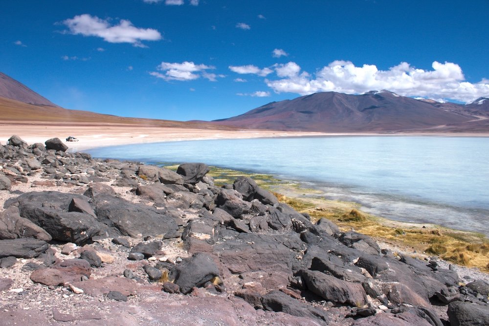 Blue-ish white lake surrounded by rocks and mountains