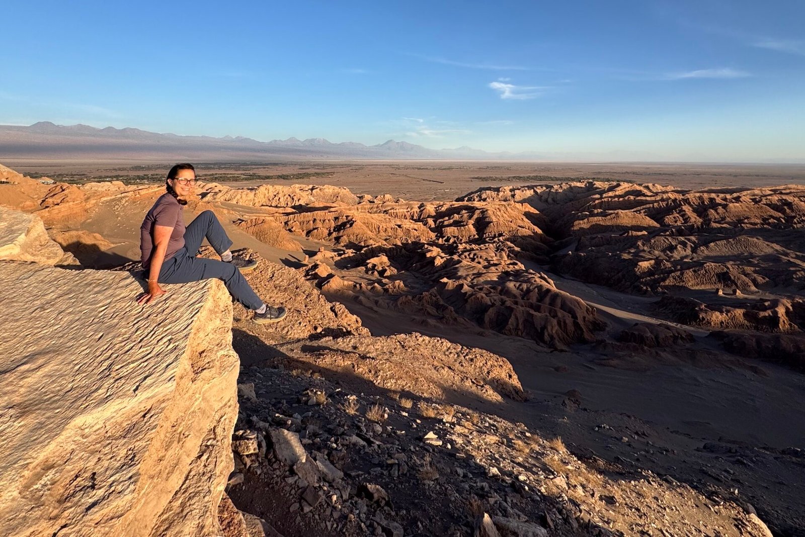 Author sitting on a rock near Moon Valley in San Pedro de Atacama, Chile