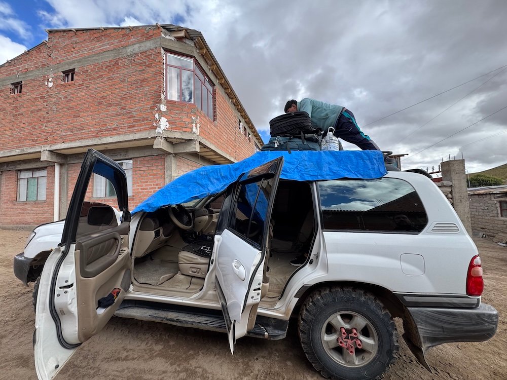 Driver loading luggage on the top of a jeep on the Uyuni Salt Flats Tour