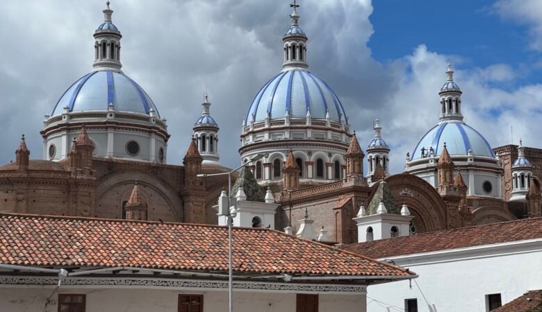 Blue domes of a cathedral rising behind buildings in Cuenca, Ecuador