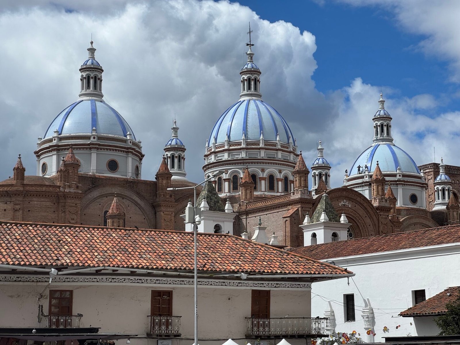 Blue domes of a cathedral rising behind buildings in Cuenca, Ecuador