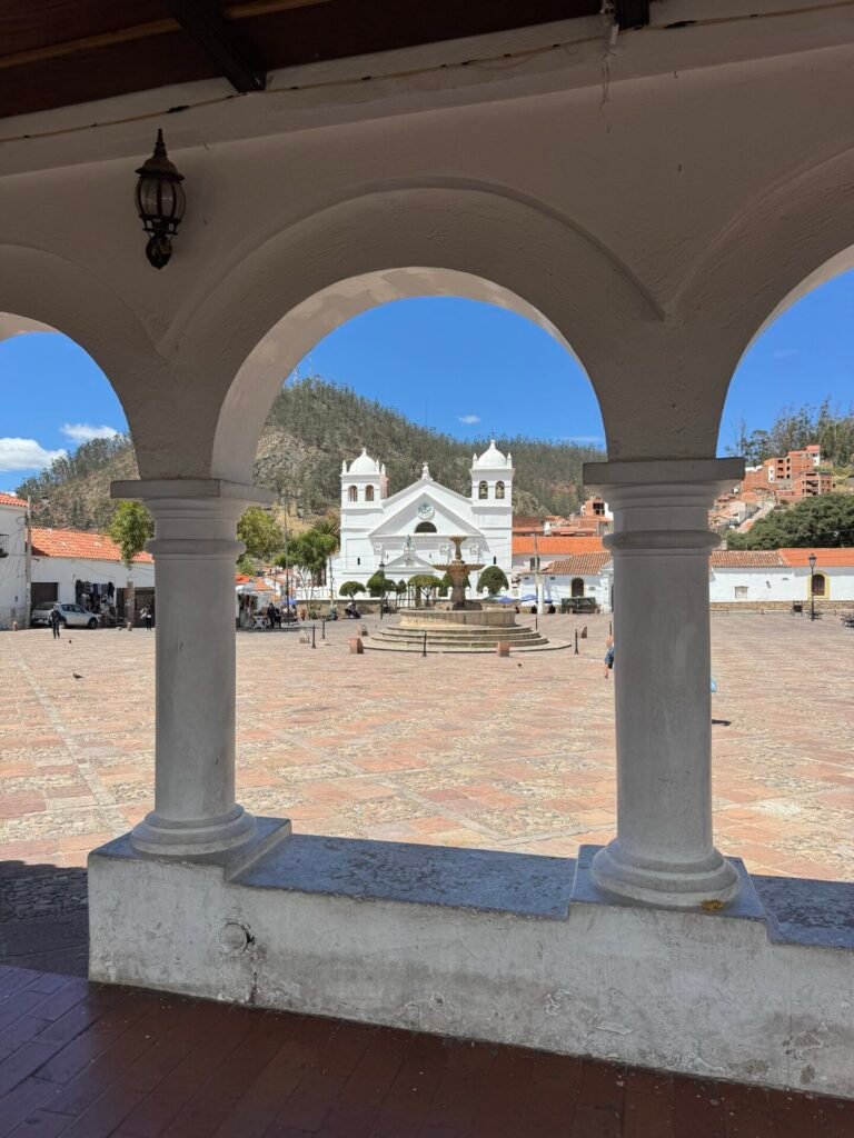 Looking through an arch at a church and plaza