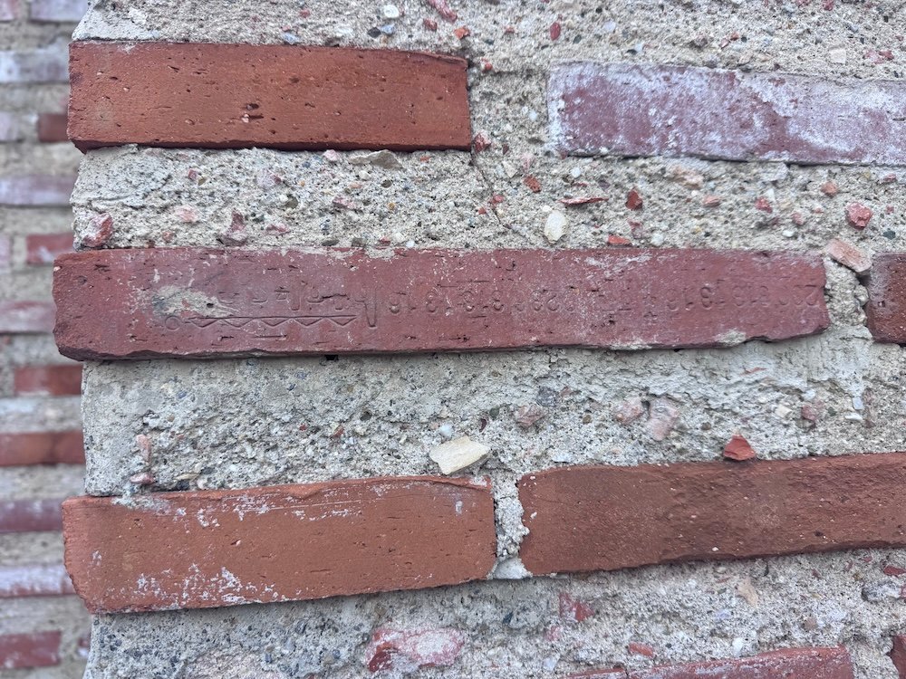 Close up of a brick showing a serial number